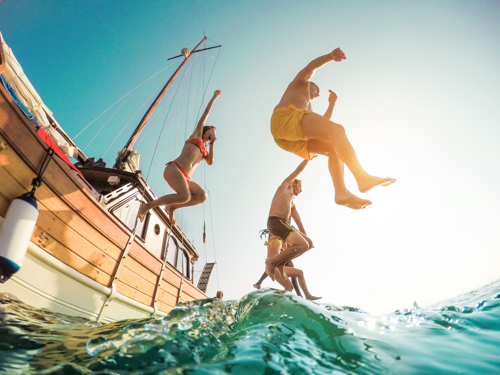 Freunde springen von einem Boot